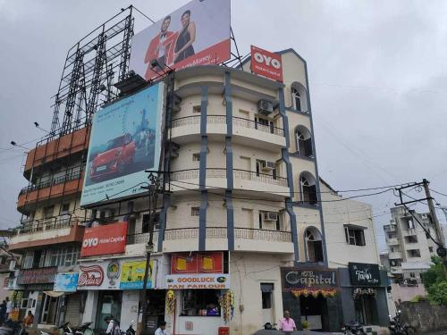 拉杰果德OYO Flagship Hotel Capital的一座高大的建筑,旁边是广告牌