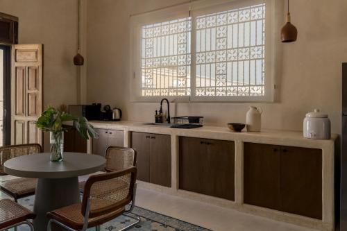 坎佩切Narrativ Lofts - Numen - Stylish Hideaway的厨房配有桌子和窗户
