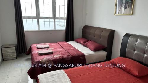 瓜拉丁加奴Ladang Tanjung Dar Assalam Homestay的一间卧室设有两张床和窗户。