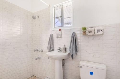 安东尼奥港Serenity 2-Bed Apartment in Port Antonio的白色的浴室设有水槽和卫生间。