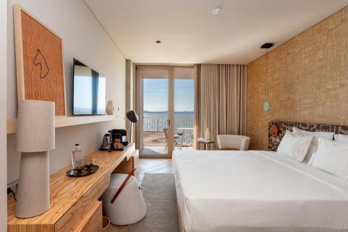 阿尔科谢蒂Upon Vila - Alcochete Hotel的酒店客房设有一张床,享有海景。