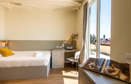 佛罗伦萨Il Santo Stays的一间卧室配有一张床、一张书桌和一个窗户。