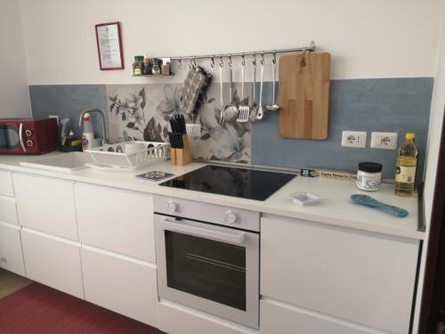 贾迪尼-纳克索斯Tulla's的白色的厨房设有水槽和炉灶。