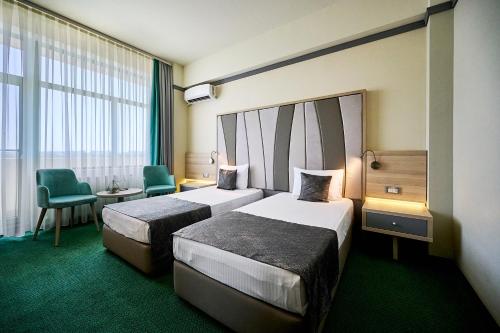 马马亚马里布酒店的酒店客房,配有两张床和椅子