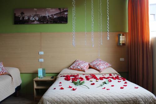 基多Hostal Terra 4 - EL LABRADOR的一间卧室,床上有红色玫瑰