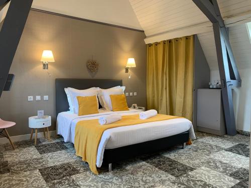图尔农－圣马丹Hotel The Originals Le Manoir de Pierre Levée的一间卧室配有一张带黄色枕头的大床