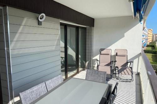 勒格罗-迪鲁瓦Le Mistral Appartement Standing vue mer的阳台的天井配有桌椅