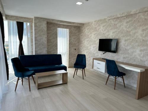 GrandPazarcıkOtel的客厅配有蓝色的沙发和两把椅子