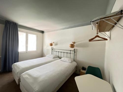 尼奥尔Grand Hôtel Niort Centre的配有窗户的酒店客房内的两张床