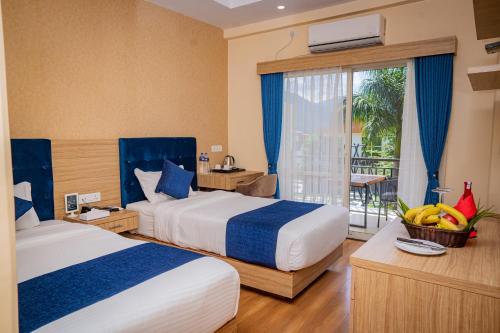 博卡拉Majestic Lake Front Hotel & Suites的酒店客房设有两张床和一个阳台。