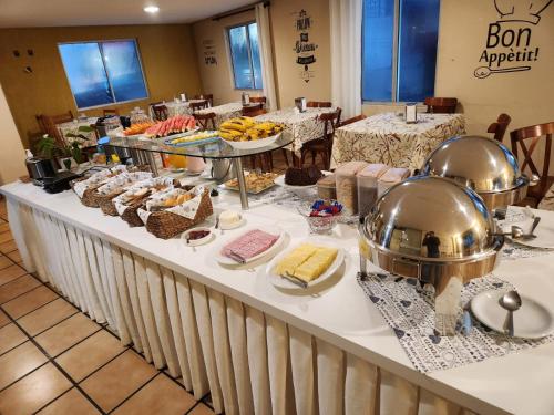 伊达贾伊Hotel Graju Itajaí的餐厅的自助餐,包括餐桌上的食品