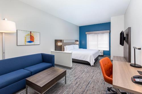 列治文山列治文山南萨凡纳I-95州际公路智选假日酒店的酒店客房,配有床和蓝色的沙发
