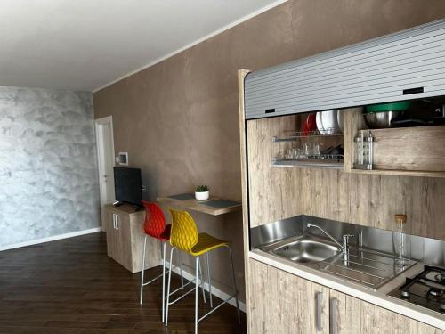 蒙特-坡佐-卡多Casa Catone (affitta camere)的厨房配有水槽和带凳子的台面