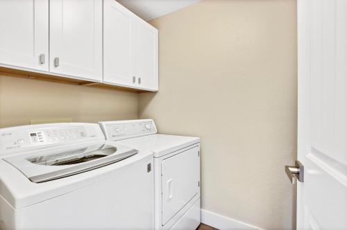 EagleStunning Golf Course Retreat 4BR Home的白色洗衣房配有洗衣机和烘干机