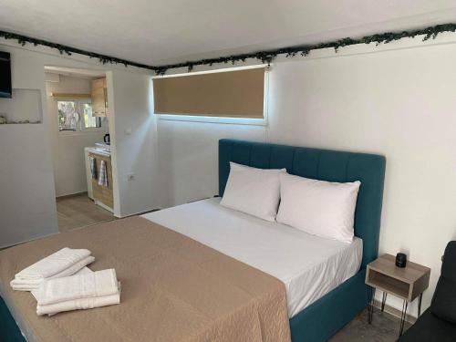 克里斯阿穆迪亚STUDIOS TASOS BI的一间卧室配有一张大床和蓝色床头板