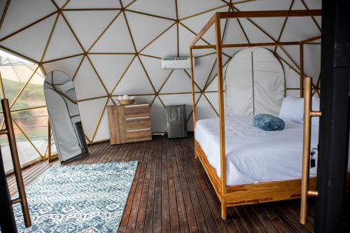瓜塔佩Elysium Glamping的蒙古包内一间卧室,配有一张天蓬床