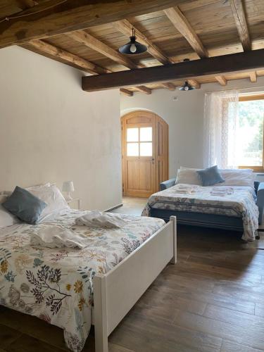 贝尔切托Agriturismo Il Mulino della Rocca的一间卧室设有两张床和木制天花板