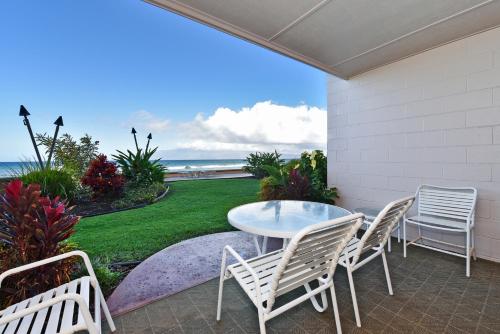 卡哈纳Makani Sands #102的一个带桌椅的庭院和大海