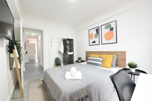 贝纳尔马德纳Nordik Apartments Village - Arroyo "Rovaniemi"的白色卧室配有大床和椅子