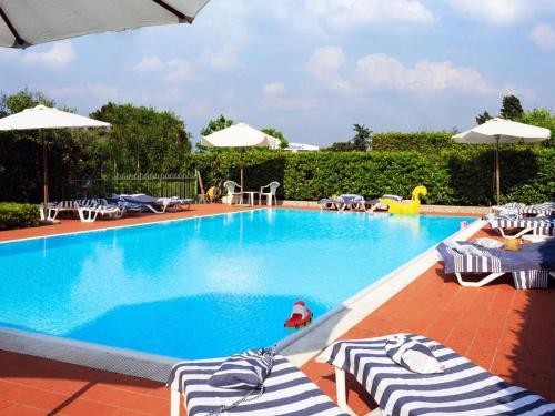 西尔米奥奈贝拉西尔米奥奈假日公寓式酒店的一个带躺椅和遮阳伞的游泳池