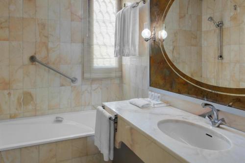 麦地那艾美梅迪纳酒店的浴室配有盥洗盆、镜子和浴缸