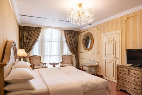 麦地那艾美梅迪纳酒店的一间卧室配有一张大床和一个吊灯。