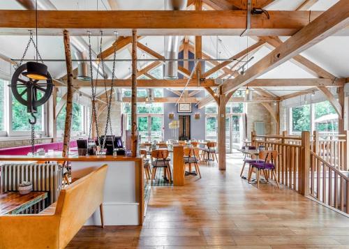 巴斯巴斯工厂小屋度假酒店的餐厅设有木制天花板和桌椅