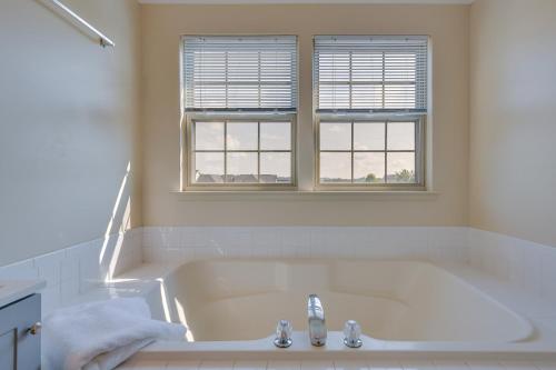奥因斯米尔斯Owings Mills Townhouse 8 Mi to Liberty Reservoir!的一个带水槽的白色浴缸和两个窗户