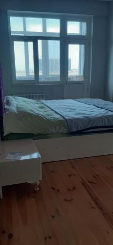 巴库My sweet home in Qara Qarayev的一张位于带2扇窗户和木地板的客房的床位