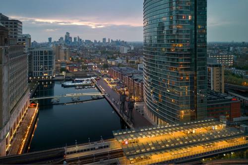 伦敦London Marriott Hotel Canary Wharf的享有河流和建筑的城市美景