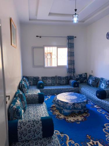西迪伊夫尼Panorama guest house的客厅配有蓝色的沙发和桌子
