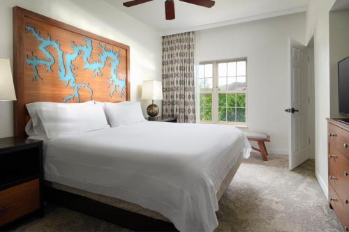 布兰森万豪威洛瑞吉别墅酒店的卧室设有一张白色大床和一扇窗户。