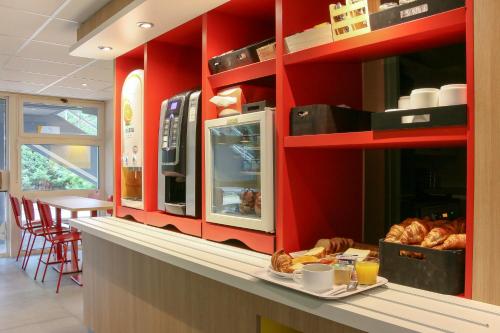 维特罗勒Premiere Classe Marseille Vitrolles Aéroport的一间带红色墙壁和面包台的厨房
