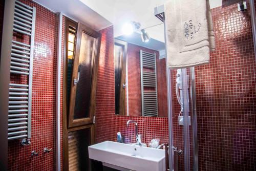 维耶特里Casa Blu的红色瓷砖浴室设有水槽和镜子