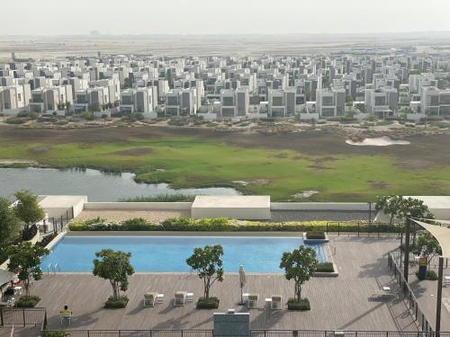 迪拜Emaar South - Two Bedroom Apartment with Pool and Golf Course View的享有城市空中景观,设有游泳池和建筑