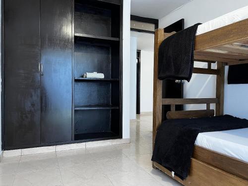 巴耶杜帕尔Apartamento Cerca Al centro的一间卧室配有一张双层床和一个黑色衣柜