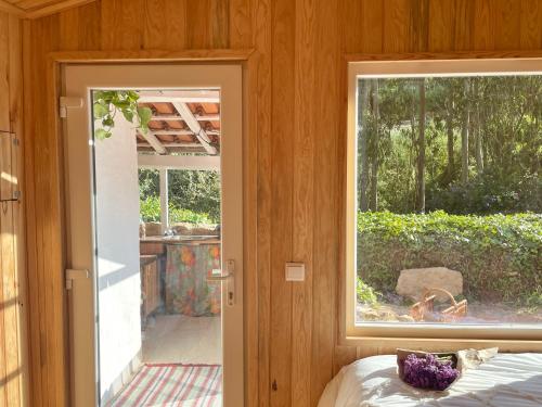 CelaNativo Natureza Pink Wood Cabin的一间设有窗户的房间和一张位于房间的床