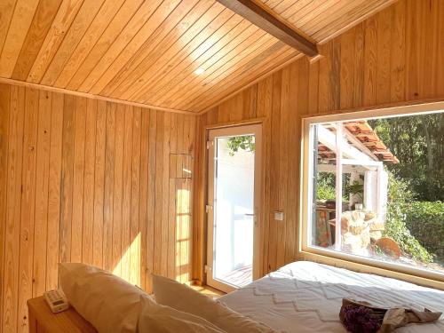 CelaNativo Natureza Pink Wood Cabin的卧室设有木墙内的大窗户