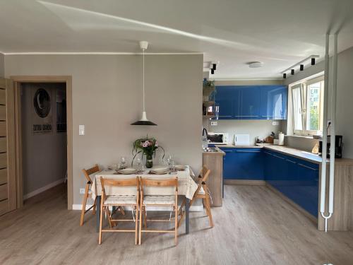格但斯克Kobalt Spot Sea Apartment的厨房配有蓝色橱柜和桌椅