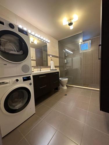 卡西罗彼卡多Spenny Sunrise Apartment的浴室配有洗衣机和烘干机。
