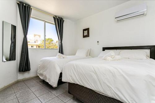 弗洛里亚诺波利斯Apto a 30 metros do mar em Canasvieiras CBE105的带窗户的客房内的两张床