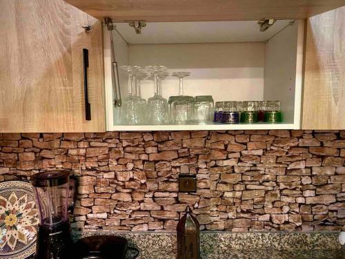 马拉喀什Splendido appartamento a Gueliz的石墙上带玻璃杯的厨房台面