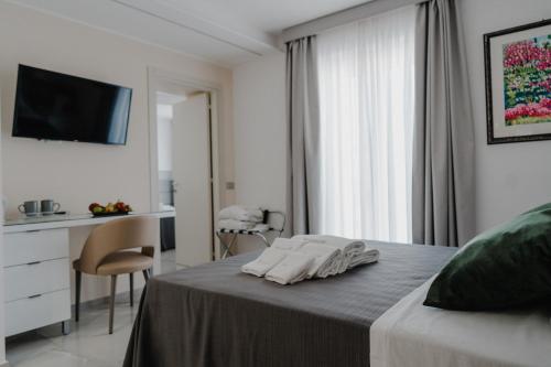 蒙特齐尔佛奈RIMIR Hotel & Centro Benessere的白色卧室配有床和书桌
