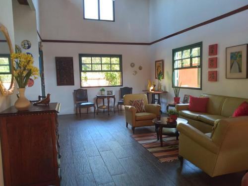 瓜皮米林Guapimirim Casa de Campo的带沙发和椅子的客厅以及窗户。