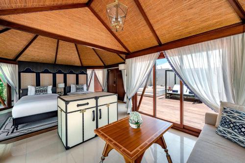 拉斯阿尔卡麦拉斯阿尔卡麦海滩悦榕庄酒店的一间卧室设有一张床和木制天花板