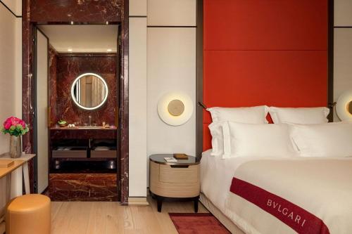 罗马Bulgari Hotel Roma的一间卧室设有一张床和红色的墙壁