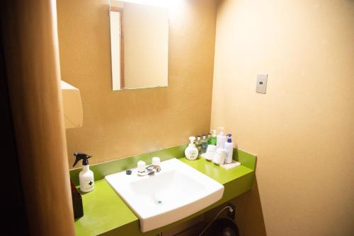 黑部市田中日式旅馆的浴室设有白色水槽和镜子