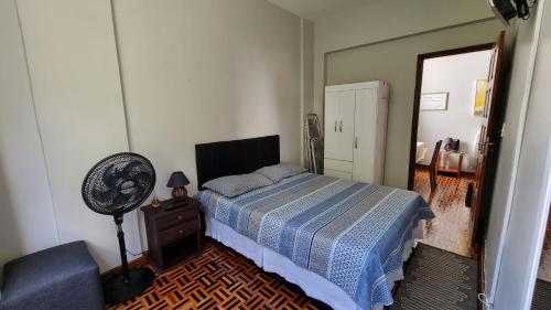 萨尔瓦多Ap Na Barra, Frente Do Farol的一间卧室配有一张床、风扇和椅子