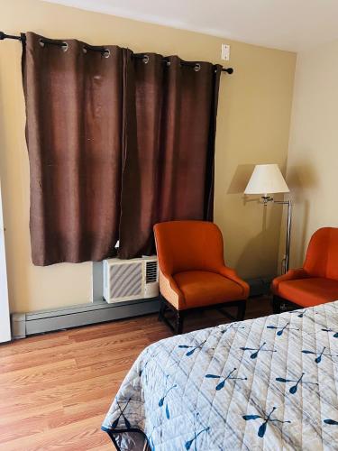 尼亚加拉瀑布Rest and Relax的一间卧室配有一张床、两把椅子和一个窗户