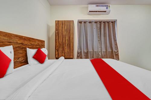 海得拉巴OYO Flagship 81135 Hotel R Square Inn的卧室配有带红色枕头的大型白色床